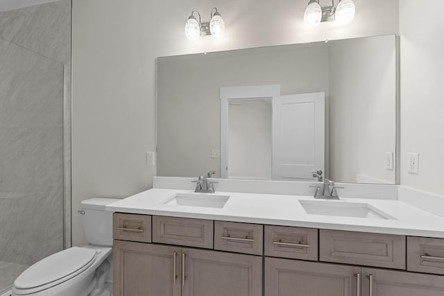 full bath with a sink, tiled shower, toilet, and double vanity