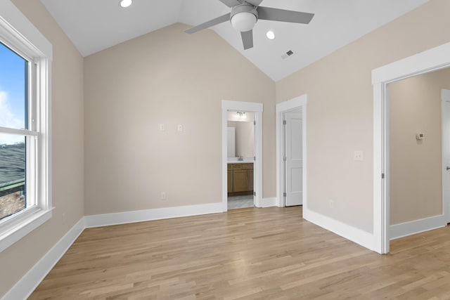 unfurnished bedroom featuring lofted ceiling, light wood-style floors, visible vents, and baseboards