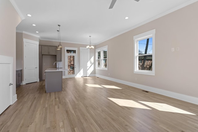 unfurnished living room with light wood-style flooring, recessed lighting, baseboards, and a sink