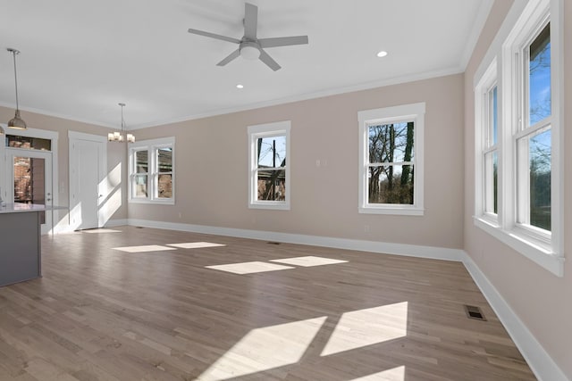 unfurnished living room featuring baseboards, visible vents, and ornamental molding