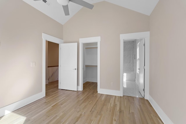 unfurnished bedroom featuring baseboards, light wood-style flooring, a spacious closet, a closet, and ensuite bathroom