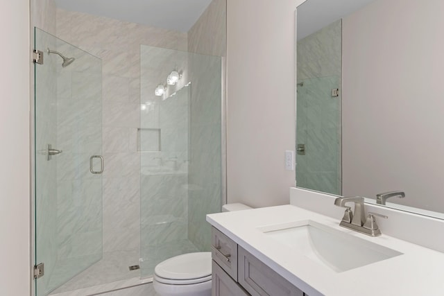 bathroom with vanity, toilet, and a stall shower