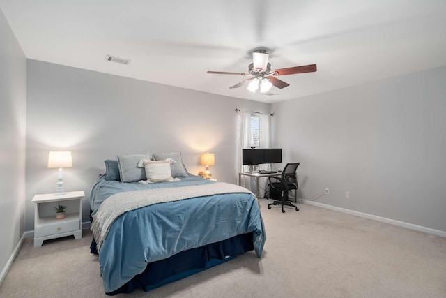 bedroom with visible vents, light colored carpet, baseboards, and ceiling fan