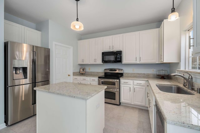 kitchen with light stone counters, a sink, appliances with stainless steel finishes, white cabinetry, and a center island