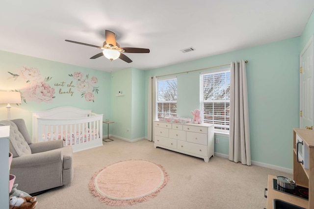 bedroom featuring visible vents, light colored carpet, baseboards, and a nursery area