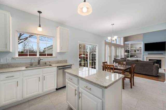 kitchen featuring a sink, stainless steel dishwasher, pendant lighting, and a center island