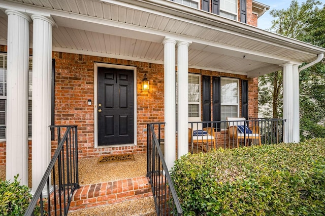 entrance to property with brick siding and covered porch