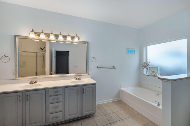 bathroom with a sink, a garden tub, double vanity, and tile patterned flooring