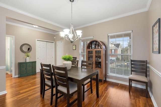 dining area featuring an inviting chandelier, wood finished floors, baseboards, and ornamental molding