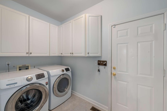 clothes washing area featuring visible vents, cabinet space, light tile patterned floors, baseboards, and washing machine and clothes dryer