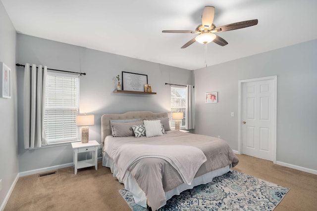 bedroom featuring light carpet, visible vents, ceiling fan, and baseboards