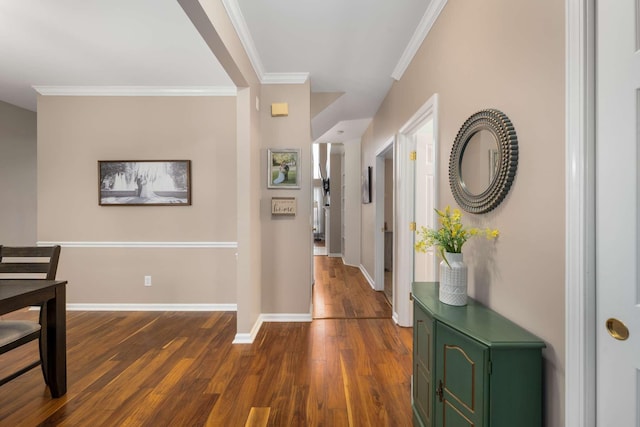 corridor with baseboards, dark wood finished floors, and ornamental molding