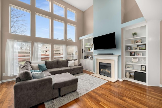 living room with a wealth of natural light, wood finished floors, and a fireplace