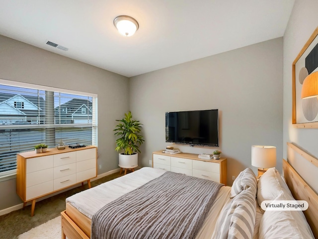 bedroom featuring baseboards, visible vents, and light carpet