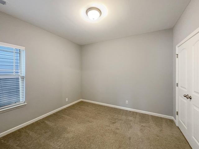 empty room with baseboards and carpet