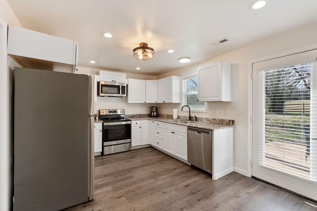 753 Theta Pike, Columbia, TN 38401 - kitchen featuring visible vents, light wood-style flooring, a sink, stainless steel appliances, and light stone countertops