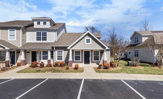 view of front of home featuring uncovered parking and roof with shingles