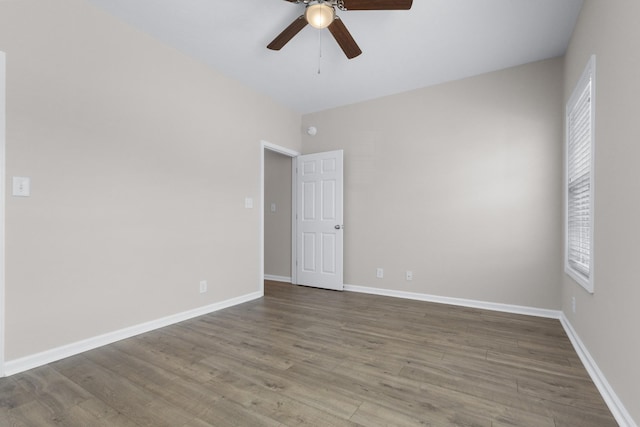 unfurnished room with a ceiling fan, baseboards, and wood finished floors