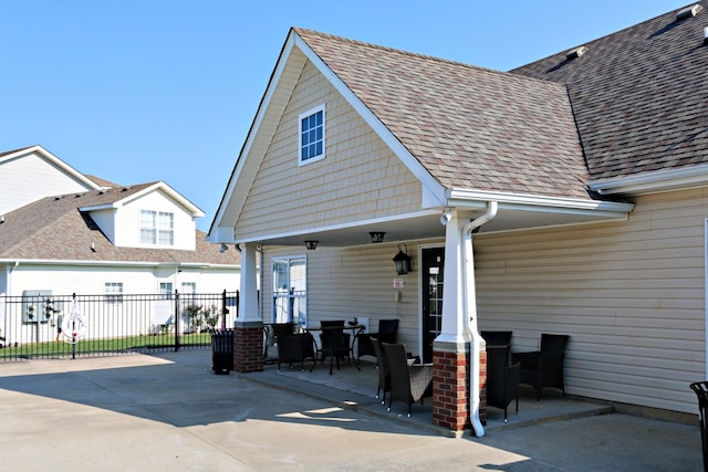 back of house featuring a patio, fence, and roof with shingles