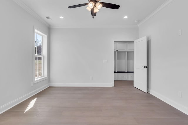 unfurnished bedroom with wood finished floors, baseboards, visible vents, and ornamental molding