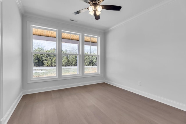 empty room featuring visible vents, ornamental molding, and dark wood finished floors