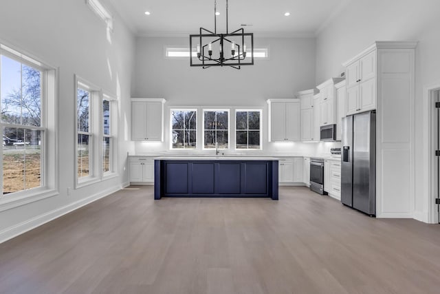 kitchen featuring crown molding, white cabinets, and appliances with stainless steel finishes