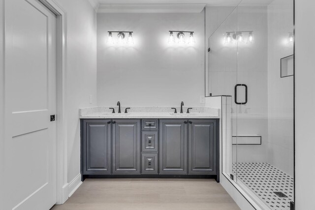 bathroom featuring a sink, ornamental molding, and a shower stall