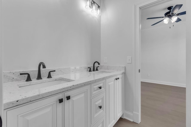 bathroom featuring a sink, baseboards, and wood finished floors