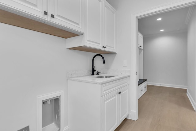 interior space with a sink, baseboards, light wood-style floors, and recessed lighting