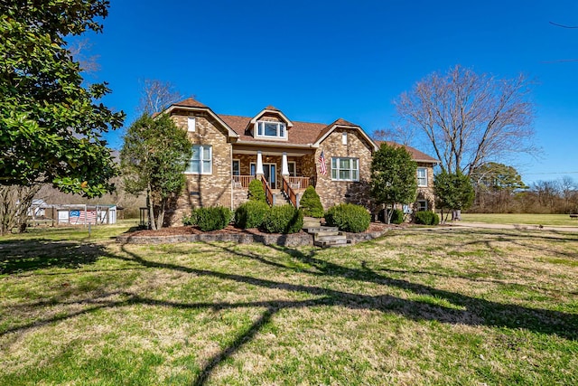 craftsman-style home with brick siding, covered porch, and a front lawn