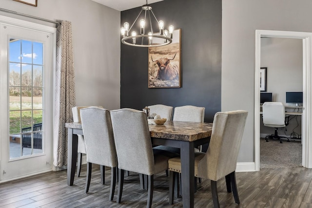 dining room with baseboards, an inviting chandelier, and dark wood finished floors