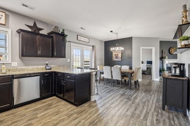 kitchen with visible vents, light wood-style flooring, dishwasher, and light stone countertops