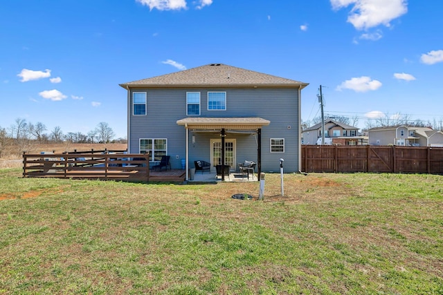 rear view of property featuring a lawn, a ceiling fan, a patio, and fence