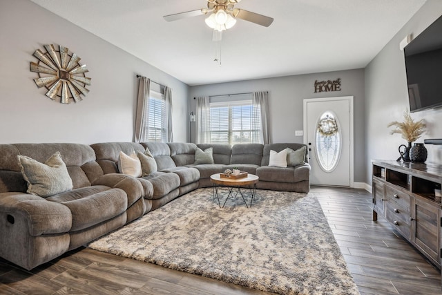 living room with baseboards, dark wood finished floors, and a ceiling fan