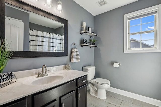 bathroom featuring vanity, baseboards, visible vents, curtained shower, and toilet