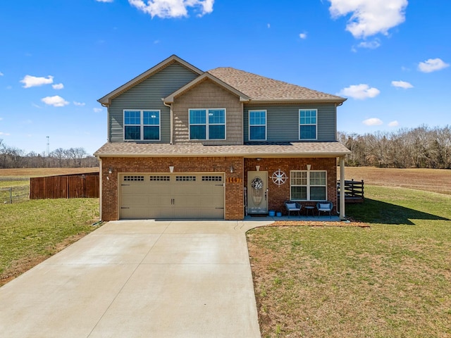 view of front facade with driveway, fence, a front yard, a garage, and brick siding