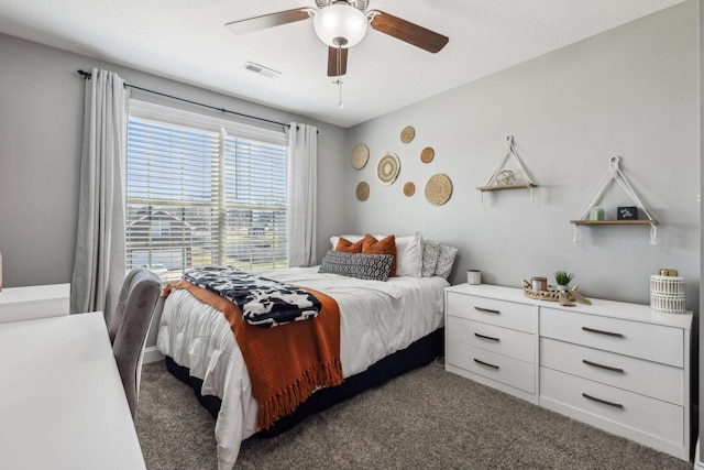 carpeted bedroom with visible vents and a ceiling fan