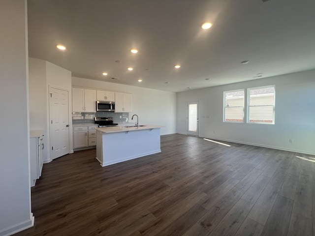 kitchen featuring dark wood-style floors, recessed lighting, a sink, appliances with stainless steel finishes, and open floor plan