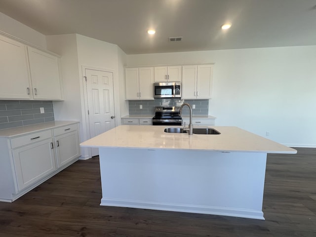 kitchen with dark wood-style floors, visible vents, stainless steel appliances, and a sink