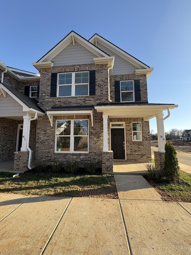 craftsman-style house with covered porch and brick siding