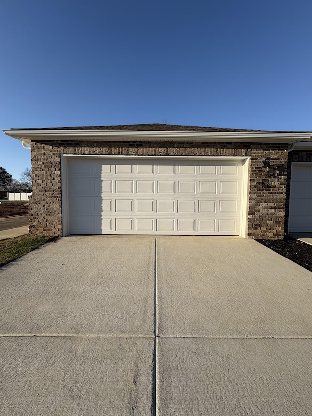 garage featuring concrete driveway