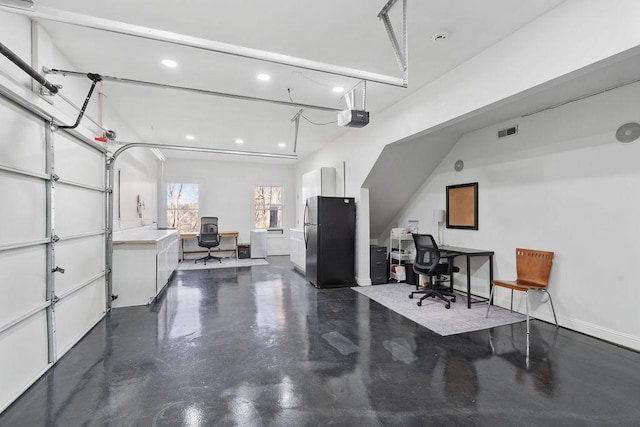 garage featuring visible vents, baseboards, recessed lighting, freestanding refrigerator, and a garage door opener