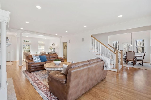 living area featuring recessed lighting, stairway, light wood-style floors, crown molding, and decorative columns