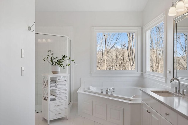 full bathroom with a shower stall, a bath, tile patterned floors, and a sink