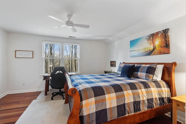 bedroom with visible vents, wood finished floors, baseboards, ceiling fan, and vaulted ceiling