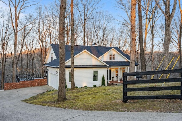 view of front of house with a front yard, fence, driveway, a chimney, and a garage