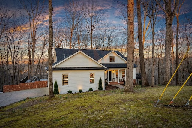 view of front of house featuring a porch, driveway, and a front yard