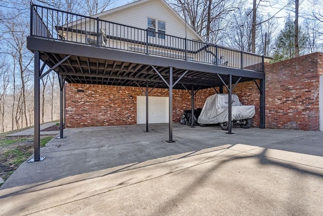 view of patio featuring a garage, driveway, and a wooden deck