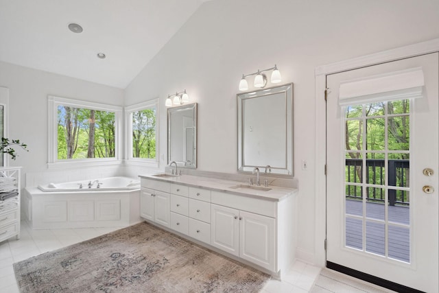 full bath with tile patterned flooring, a garden tub, a sink, and double vanity