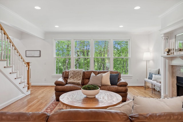 living area with baseboards, a healthy amount of sunlight, and stairs